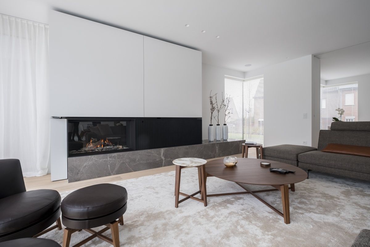 Salon contemporain avec cheminée et manteau en pierre.